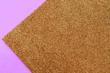 golden glitter texture on pink background. top view. flat lay