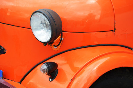 Detail of an old classic car with headlight and radiator.の写真素材