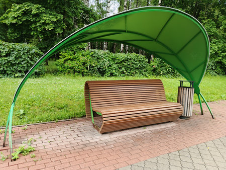 Bench in the park with a green canopy in the form of an archの写真素材