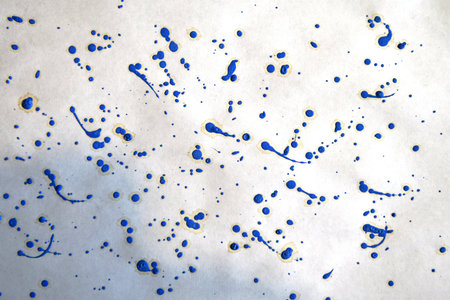 Blue ink splatter on white paper background. Abstract blue watercolor texture.の写真素材