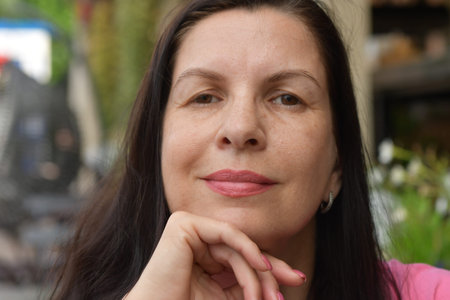 Portrait of a beautiful middle-aged woman in a summer cafe