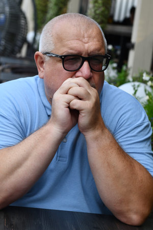 Senior man with eyeglasses sitting at a table in a restaurant