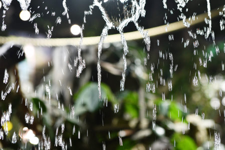 Water splash in the garden with bokeh defocused background.