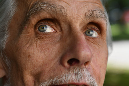 Close-up portrait of an old man with a surprised expression.