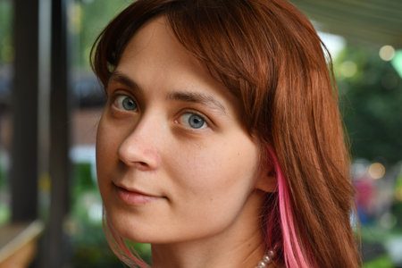 Portrait of beautiful young woman with pink hair and frecklesの写真素材