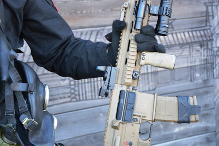 Soldier with a machine gun on the background of a wooden wall
