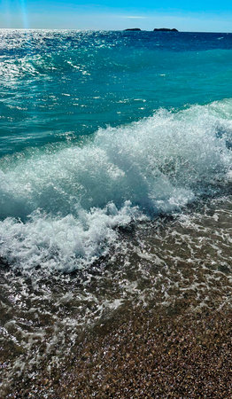 Sea waves on the pebble beach. Shallow depth of field.