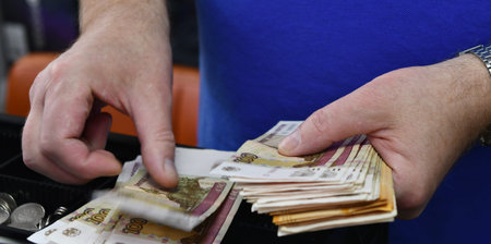 Close up of a man counting money in his wallet, focus on the hand