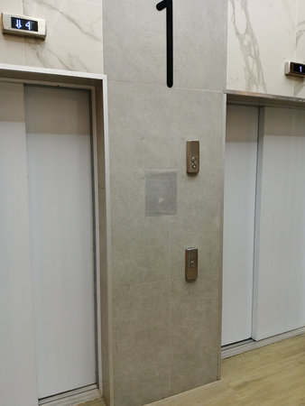 Interior of a hotel room with elevator doors and lockers.