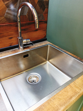Modern stainless steel kitchen sink with faucet in the kitchen.の写真素材