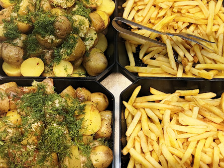 Fried potatoes with dill in a plastic box. Selective focus.