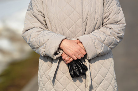 close up of woman hands in winter jacket and gloves, shallow depth of field
