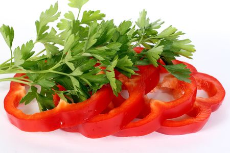 The cut sweet pepper and parsley leaves on a white backgroundの写真素材