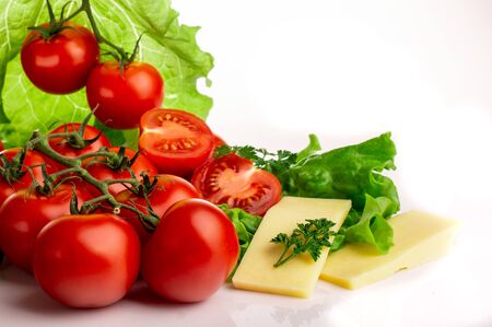 cherry tomatoes on lettuce leaves on white backgroundの写真素材