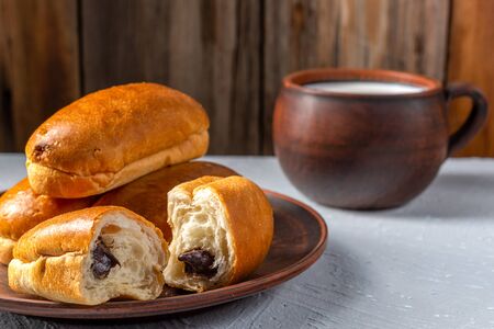 Breakfast, bun with chocolate, cookies and a Cup of milk on a dark textured background, top viewの写真素材