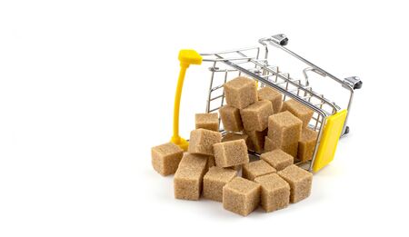 lumpy dark cane sugar in a shopping cart on a white isolated background, close-upの写真素材
