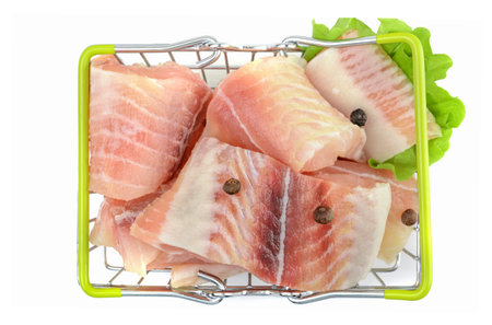 Pangasius fish fillet, sliced into pieces in the shopping basket. Isolated on a white background....