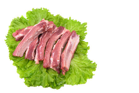 Raw pork ribs on a lettuce leaf are isolated on a white background.の写真素材