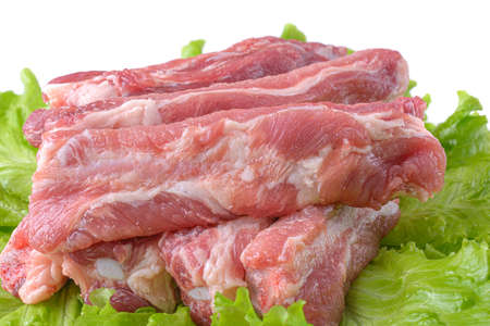 Raw pork ribs on a lettuce leaf are isolated on a white background.の写真素材