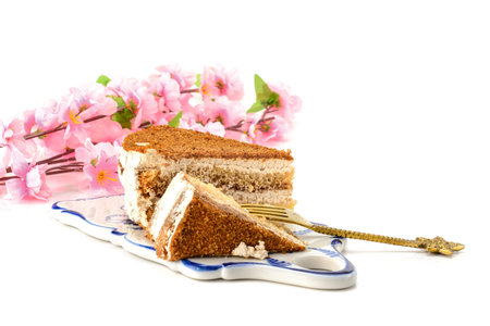 Cake, a slice of delicious honey cake. A piece of cake on a porcelain platter. Isolated on a white...