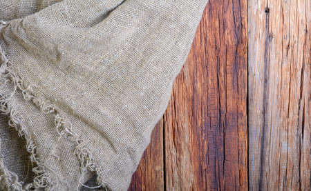The texture of burlap on old sun-bleached boards. rustic style. Natural texture of aged boards and linen and with creases and shadows.Background.の写真素材