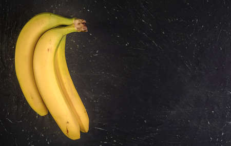 ripe bananas on a dark textured background, top viewの写真素材