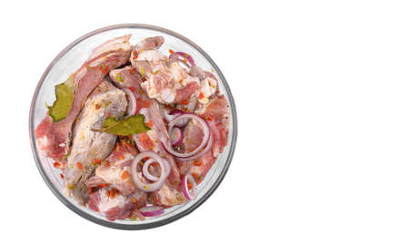 Pork ribs, sliced and marinated with onions, meat in a glass bowl, white isolated background, close-up., Top view, Selective Focus.の写真素材