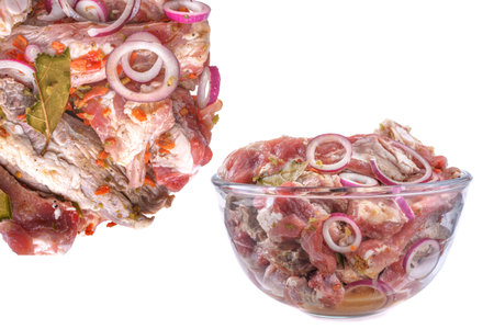 Pork ribs, sliced and marinated with onions, meat in a glass bowl, white isolated background, close-up. Top view, Selective Focus.の写真素材