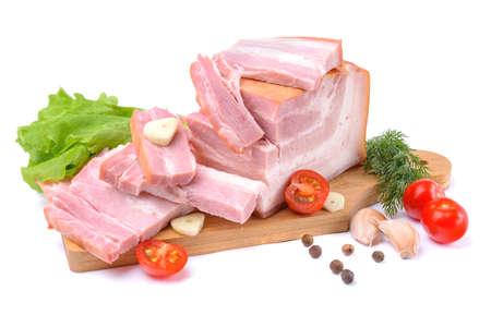 Smoked pork belly, bacon, ham on a wooden chopping board. White isolated background. Top view.の写真素材