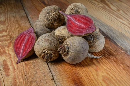 Fresh red homemade beets, whole and cut, on a wooden rustic table, vegetable food, local products, close-up, macro.の写真素材