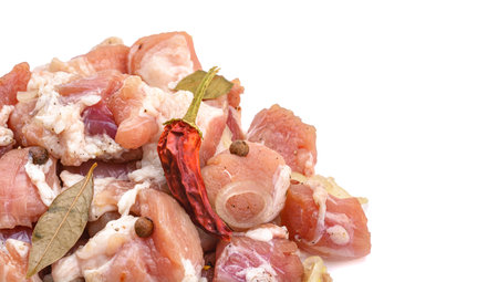 Raw pieces of pork shish kebab in marinade with pepper, onion, bay leaf, ready to cook, barbecue meat, isolated on a white background. Top view. Selective Focus.の写真素材