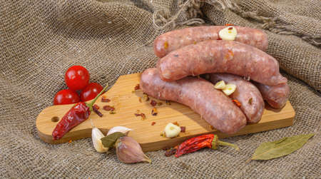 Raw pork sausages.Fried sausages close-up, with spices on old burlap.Selective focus.の写真素材