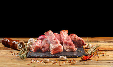 Raw pork ribs laid out on a round cutting board.Spices for cooking meat dishes, close-up.Selective Focus.の写真素材