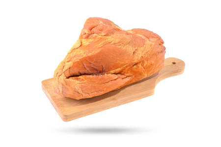 Smoked meat or ham in a large piece on a wooden board, isolated on a white background horizontal viewの写真素材