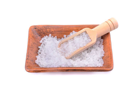 Sea salt in a salt shaker with a wooden ladle isolated on a white backgroundの写真素材