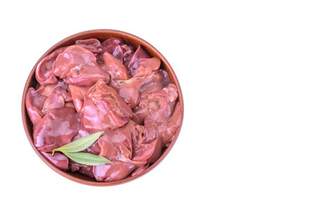 raw chicken or goose liver with bay leaf in a clay bowl close-up, isolated on a white backgroundの写真素材