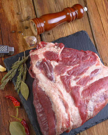 Raw pork ribs are laid out on a cutting board.Spices for cooking meat dishes close-up.Selective Focus.の写真素材