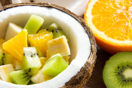 fruit salad with kiwi orange and banana in half a ripe coconutの写真素材