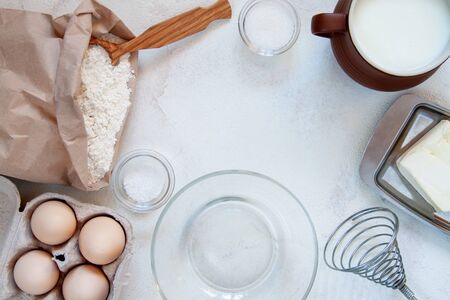 Ingredients for making dough for homemade pancakes for breakfast. On the table are wheat flour, eggs, butter, sugar, salt, milk. Selective focus. Sequencingの写真素材