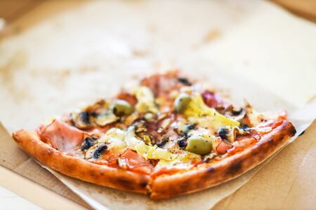 two slices of pizza in the box, front view, lefovers, natural look tasty pizzaの写真素材