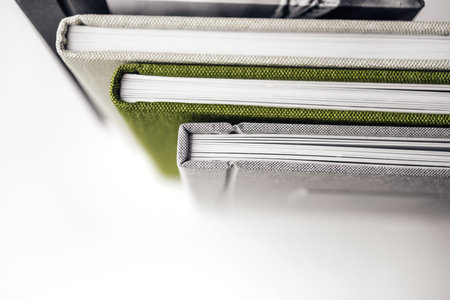 four textile photobooks standing on the table, close up top view