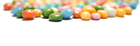 Banner made of assorted bean candies making a frame on the top with white copy space below.