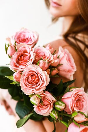 Close up of a pink roses bouquet in womans arms. No face, close up.の写真素材