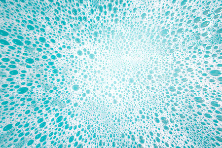 Abstract background made of white foam bubles on aqua color water