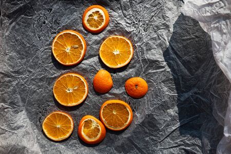 The process of drying orange slices in intence sunlight on pergament paperの写真素材