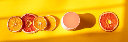 Flat lay composition on orange background. Banner with organic citrus rean and dry oranges. Sun stripes.の写真素材