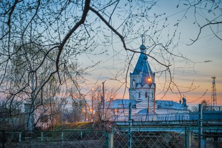 church and tree branches at sunset in the spring in city Lihoslavlの写真素材