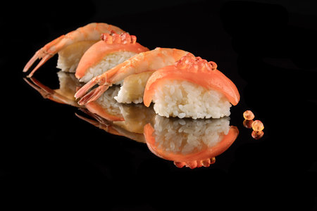 Japanese Sushi whith salmon and shrimps on black background and whith reflection. Organic food.の写真素材