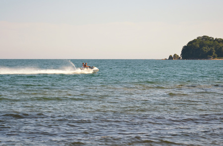 The scooter is racing along the waves.の写真素材