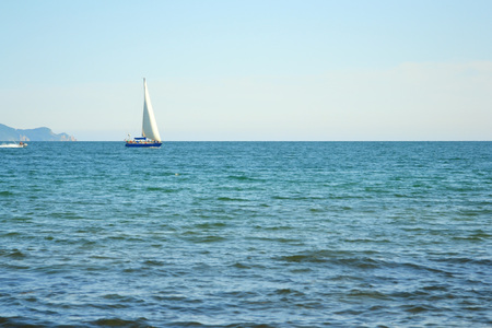 Yacht sailing on the horizont on open seaの写真素材